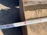 a measuring tape that is on the ground next to a bench