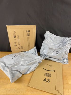 three bags of amazon boxes sitting on top of a wooden table