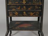 an image of a small black and gold chest of drawers
