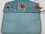 a close up of a blue purse with a flower design on it