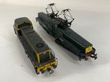 two toy trains sitting side by side on a white surface