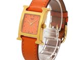 an image of an orange watch with a gold case on a white background