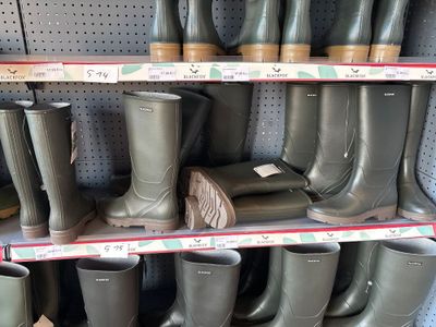 many pairs of rain boots on the shelves in the store