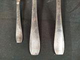 three spoons and a fork on a black cloth