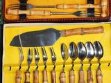 many forks and spoons in a case on the table