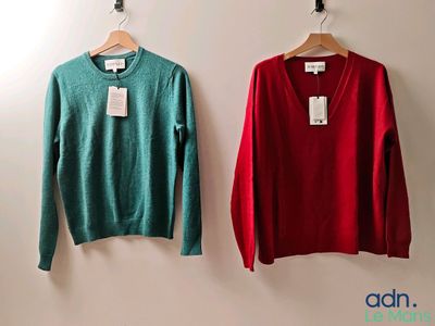 deux pulls, un rouge et un vert, accrochés l'un à côté de l'autre sur un mur