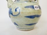 un vase bleu et blanc sur lequel est accrochée une étiquette