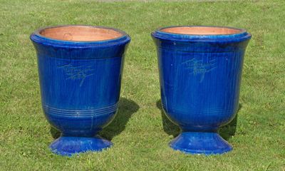 deux vases bleus posés sur l'herbe dans le jardin