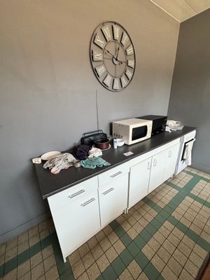 une horloge accrochée au mur au-dessus d'un plan de travail dans une cuisine
