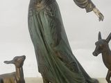 a statue of a woman and two deers on a marble base