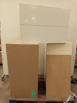 Deux cartons sont empilés sur une palette dans un entrepôt.