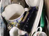 une boîte en carton remplie d'assiettes et de tasses de toutes sortes