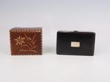deux portefeuilles, l'un noir et l'autre marron, posés l'un à côté de l'autre sur une surface blanche