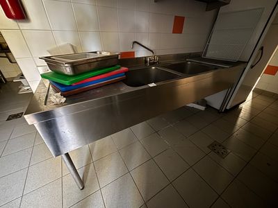 un évier en acier inoxydable dans une cuisine équipée d'un plan de travail en métal