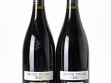 two bottles of red wine sitting next to each other on a white surface