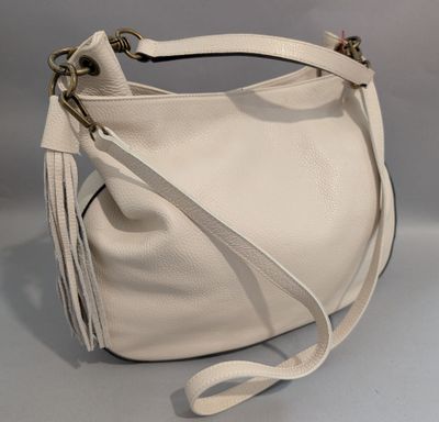 un sac à main blanc dont la bandoulière est ornée d'un pompon