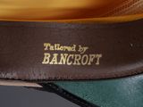 the bottom of a pair of brown and green shoes with gold lettering