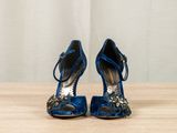 pair of blue high heeled shoes sitting on top of a wooden table