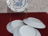 trois assiettes posées sur une table rouge recouverte d'une nappe rouge