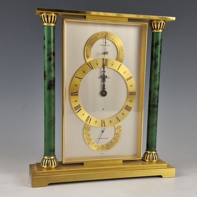 une horloge dorée et verte, avec des chiffres romains