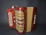 an image of a red accordion sitting on top of a black table