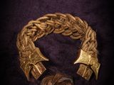 a close up of a gold bracelet on a black background
