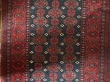a red and blue rug on a wooden floor next to a window