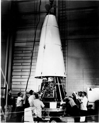 une vieille photo en noir et blanc montrant un groupe de personnes rassemblées autour d'une fusée spatiale
