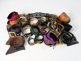 a pile of assorted leather and metal items on a white surface