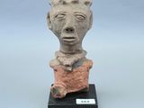 une image représentant une sculpture en argile représentant une tête d'homme posée sur un socle noir