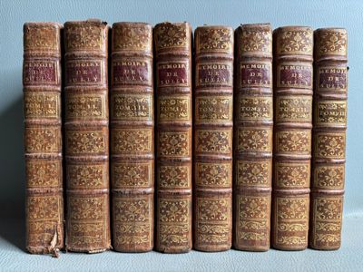 plusieurs vieux livres sont alignés sur une étagère