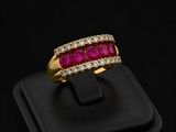 a ruby and diamond ring on a black surface