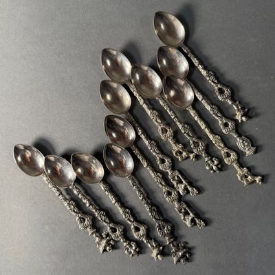 six silver spoons are arranged in a row on a gray surface