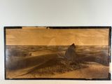 an old photo of a desert scene with a rock in the foreground