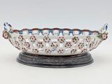 a white bowl sitting on top of a wooden stand