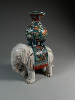 a statue of an elephant with a vase on top of it