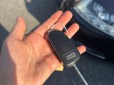 une personne tenant une clé de voiture devant une voiture