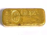 gros plan d'un lingot d'or sur une surface blanche