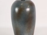 a blue vase with a black lid on a white surface