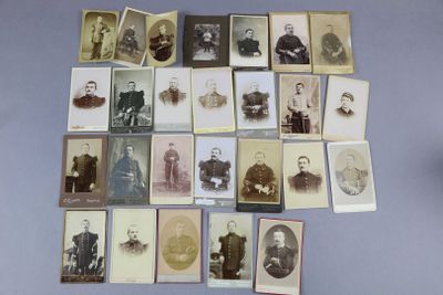 Plusieurs vieilles photos d'hommes et de femmes sont exposées sur une table