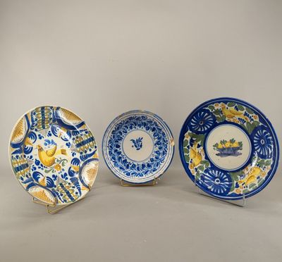 trois assiettes bleues et blanches ornées de fleurs jaunes