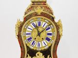 une horloge en or surmontée d'une statue