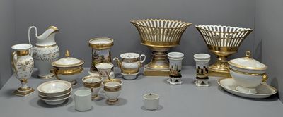 une table sur laquelle sont disposés de nombreux objets dorés et blancs