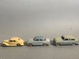 four toy cars are lined up in a row on a gray surface
