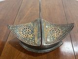 a metal object on a wooden table with a white background