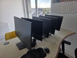 three computer monitors on a desk with a keyboard and mouse