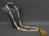 a white and gold beaded necklace with a gold turtle pendant