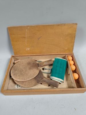 une boîte en bois contenant un jeu de raquettes de ping-pong