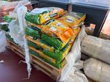 many bags of food on a pallet in a store