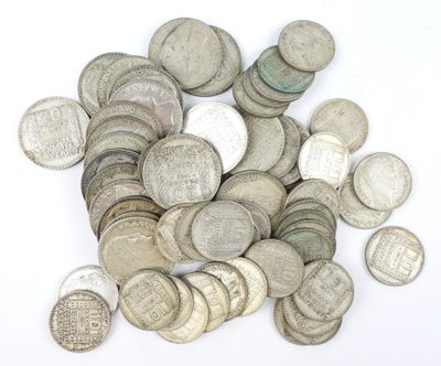 une pile de vieilles pièces d'argent sur une surface blanche